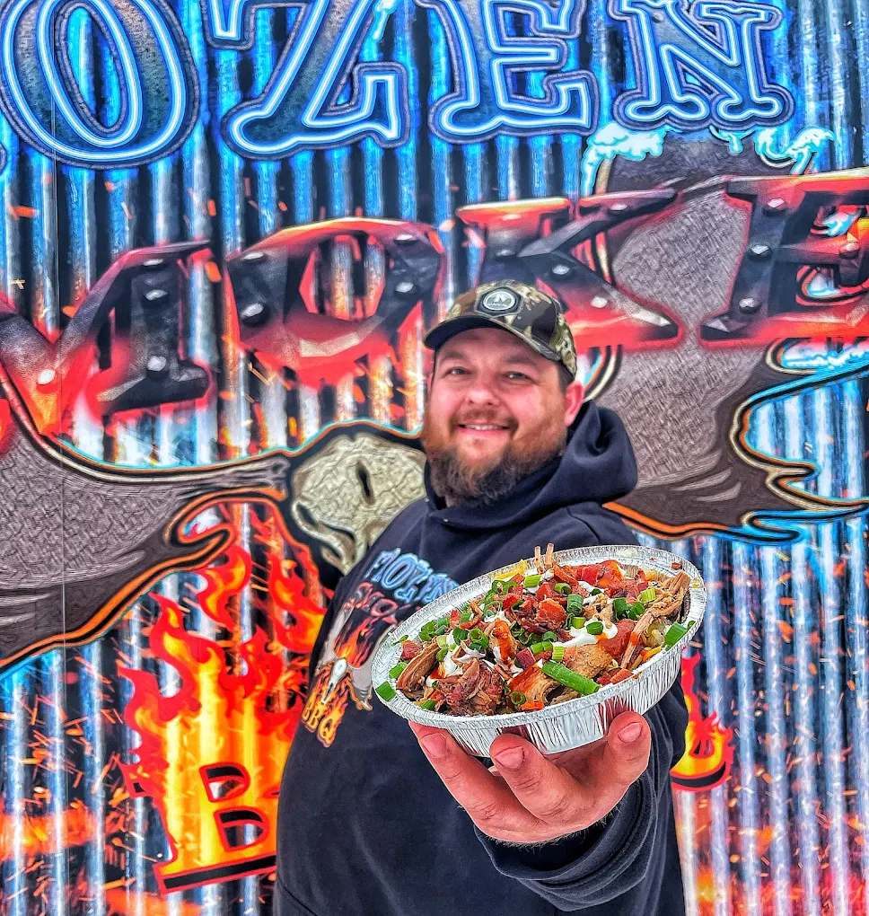 Frozen Smoke BBQ pitmaster holding loaded pulled pork nachos